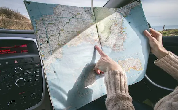 Person holding map inside vehicle. Photo by Dominika Roseclay.